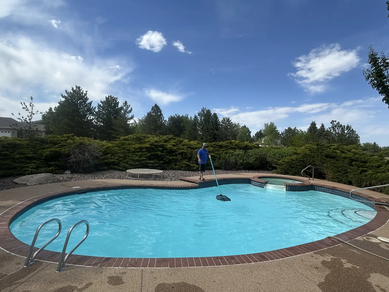 Crystal-clear freeform pool with raised spa serviced by Pyle's in Broomfield, CO