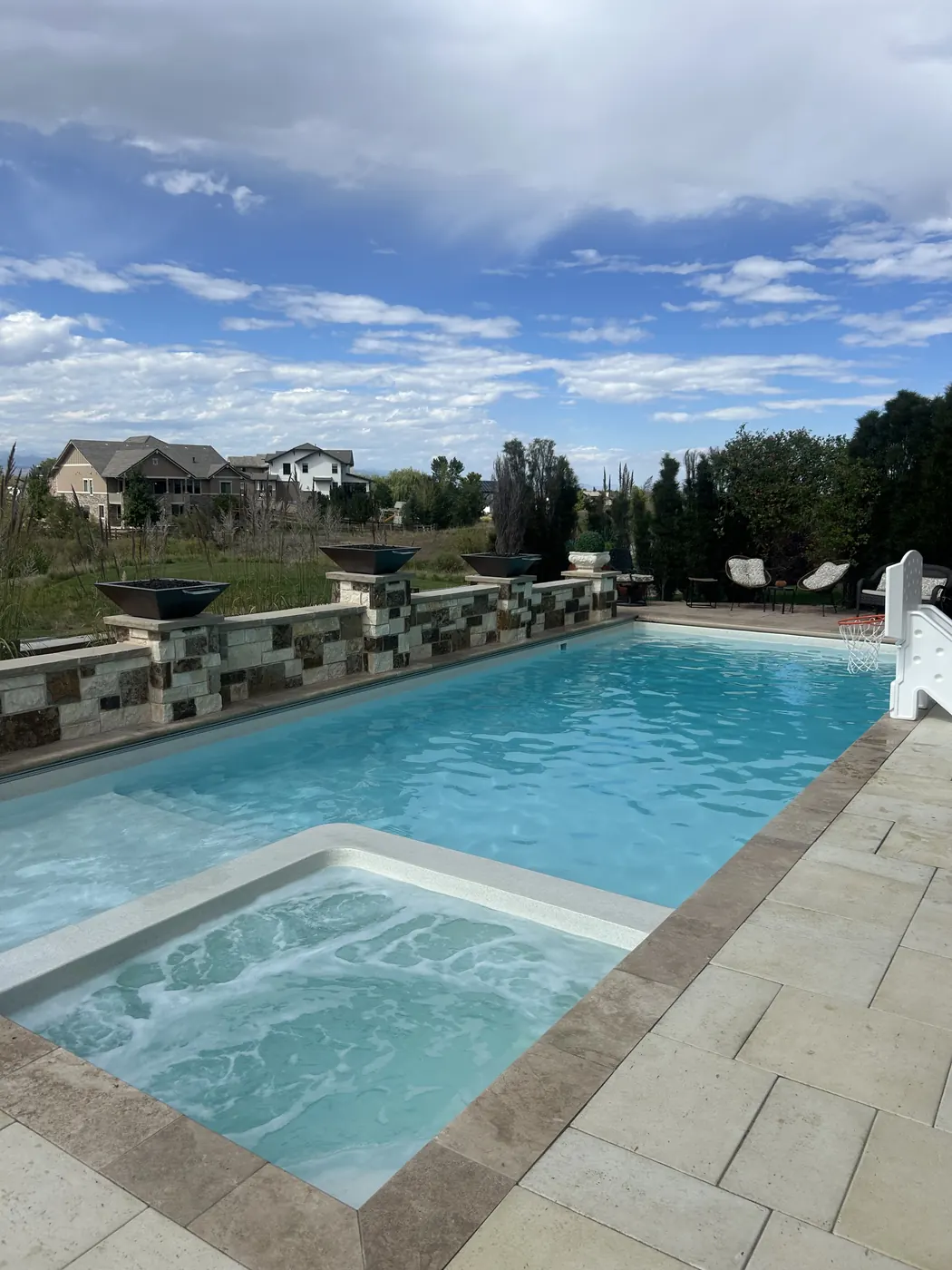 Pool with attached spa and fire bowls serviced by Pyle's in Erie, CO