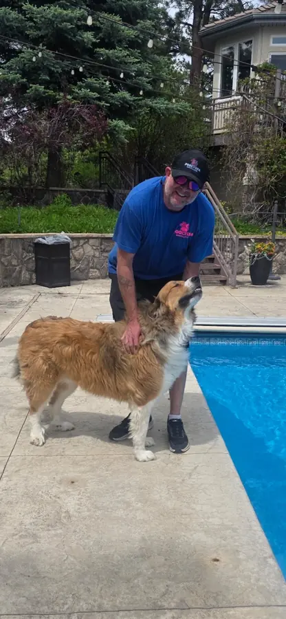 Pyle's Pool & Spa technician greeting a friendly dog poolside — we love our customers' pets