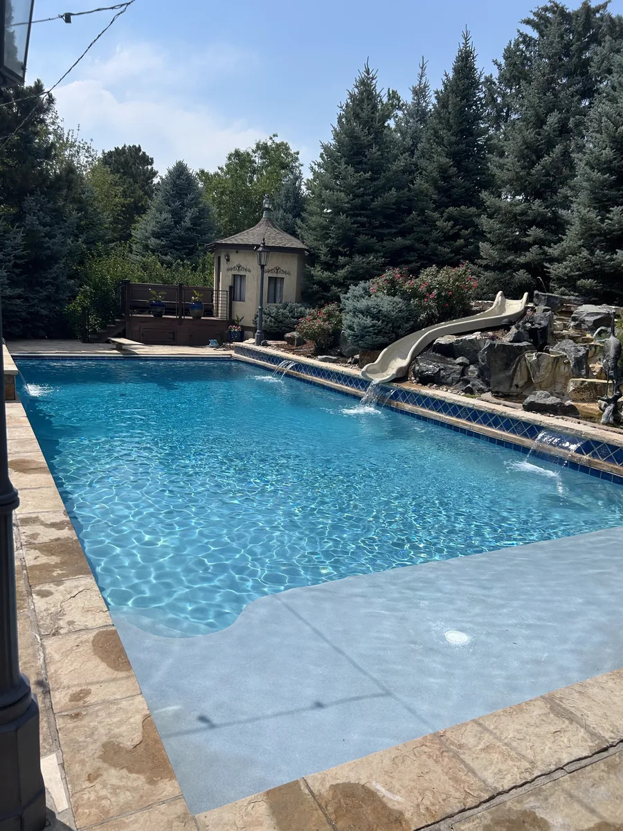 Estate pool with rock waterfall and slide maintained by Pyle's in Greenwood Village, CO