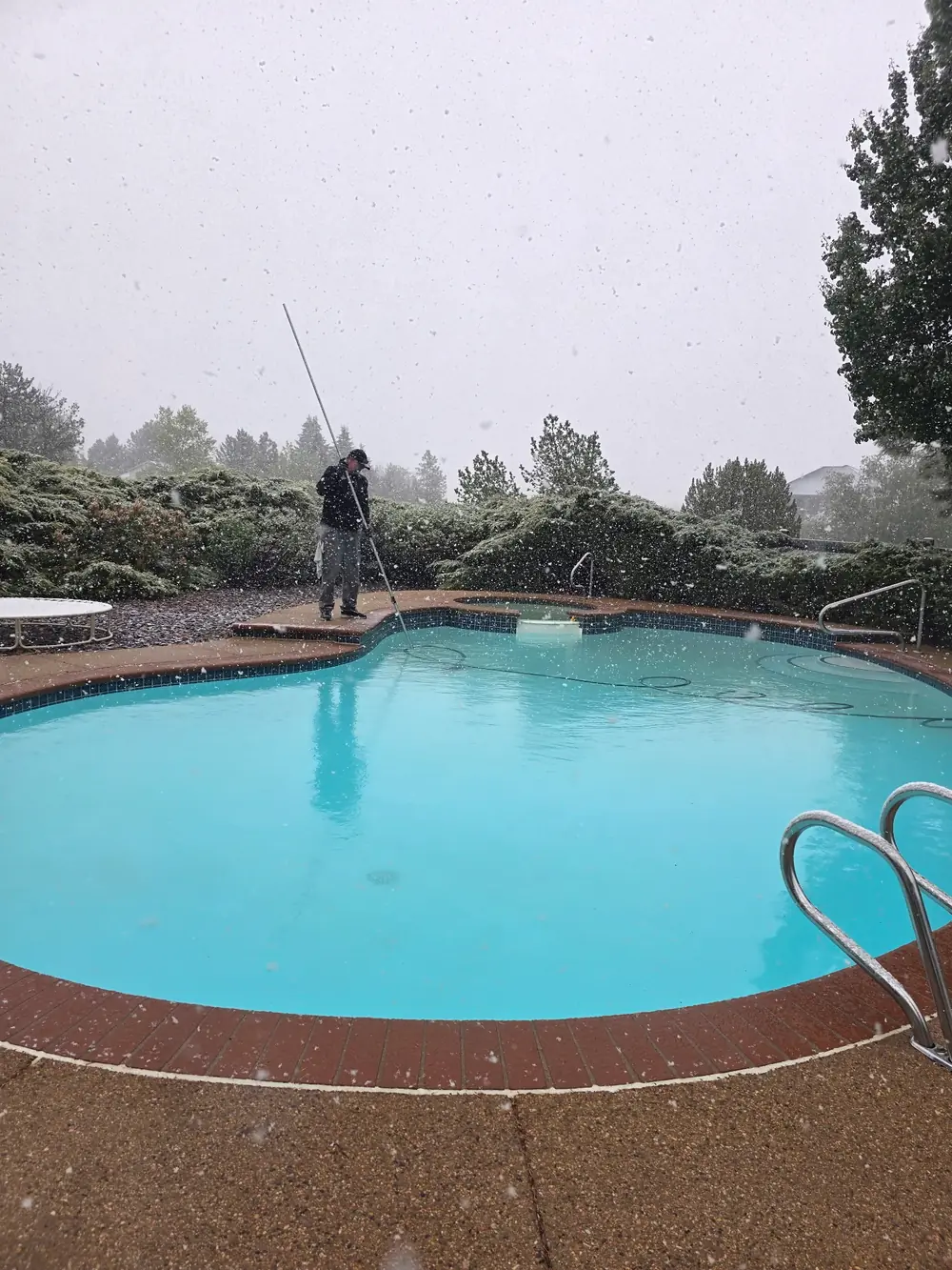 Joel skimming a turquoise pool during active Colorado snowfall — Pyle's shows up rain or shine